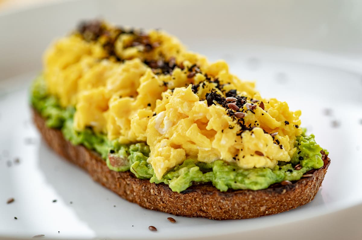 Avocado toast com ovos mexidos, opção proteica para café da manhã saudável. 